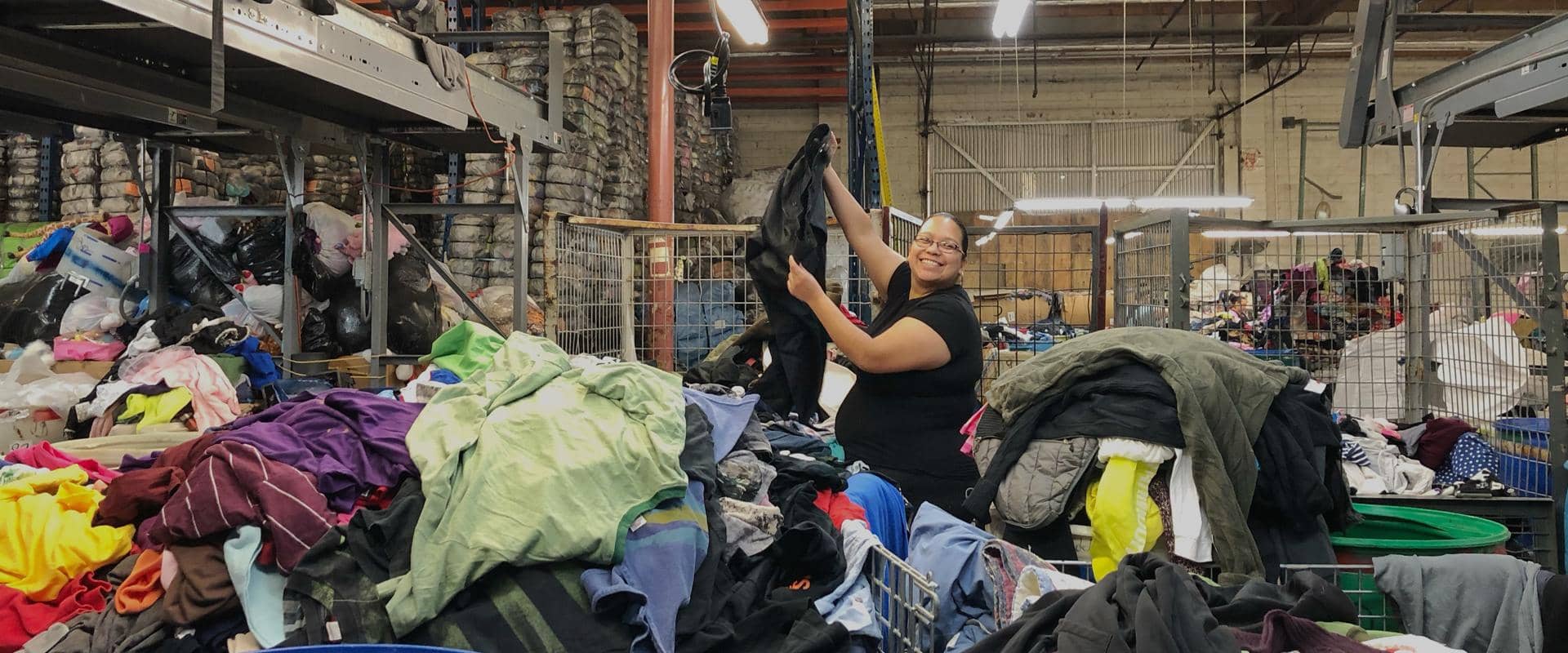 Person sorting clothes in a warehouse setting